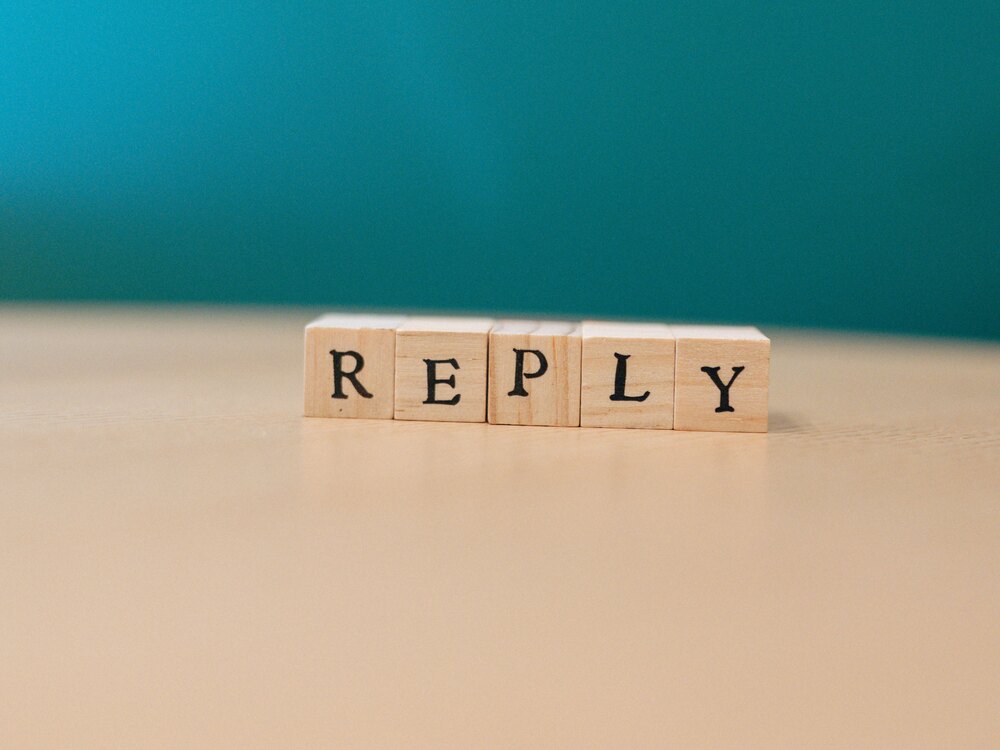 Holzbuchstaben, die das Wort „Reply" bilden